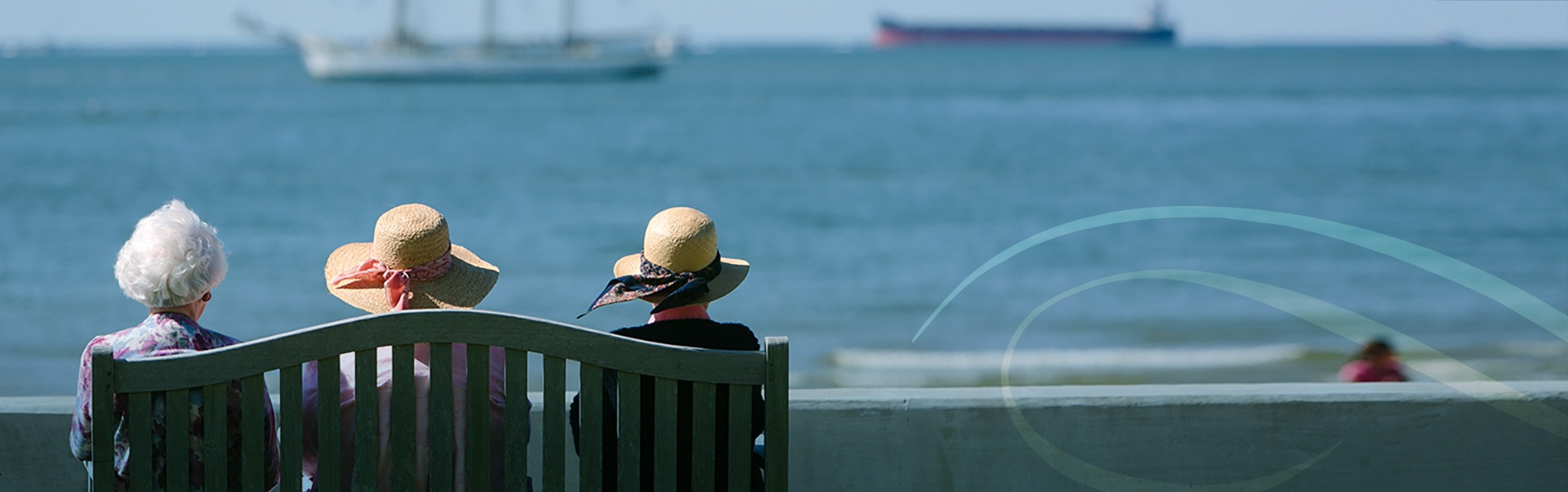 Group of Woman Sitting on a Bench Looking at the Ocean