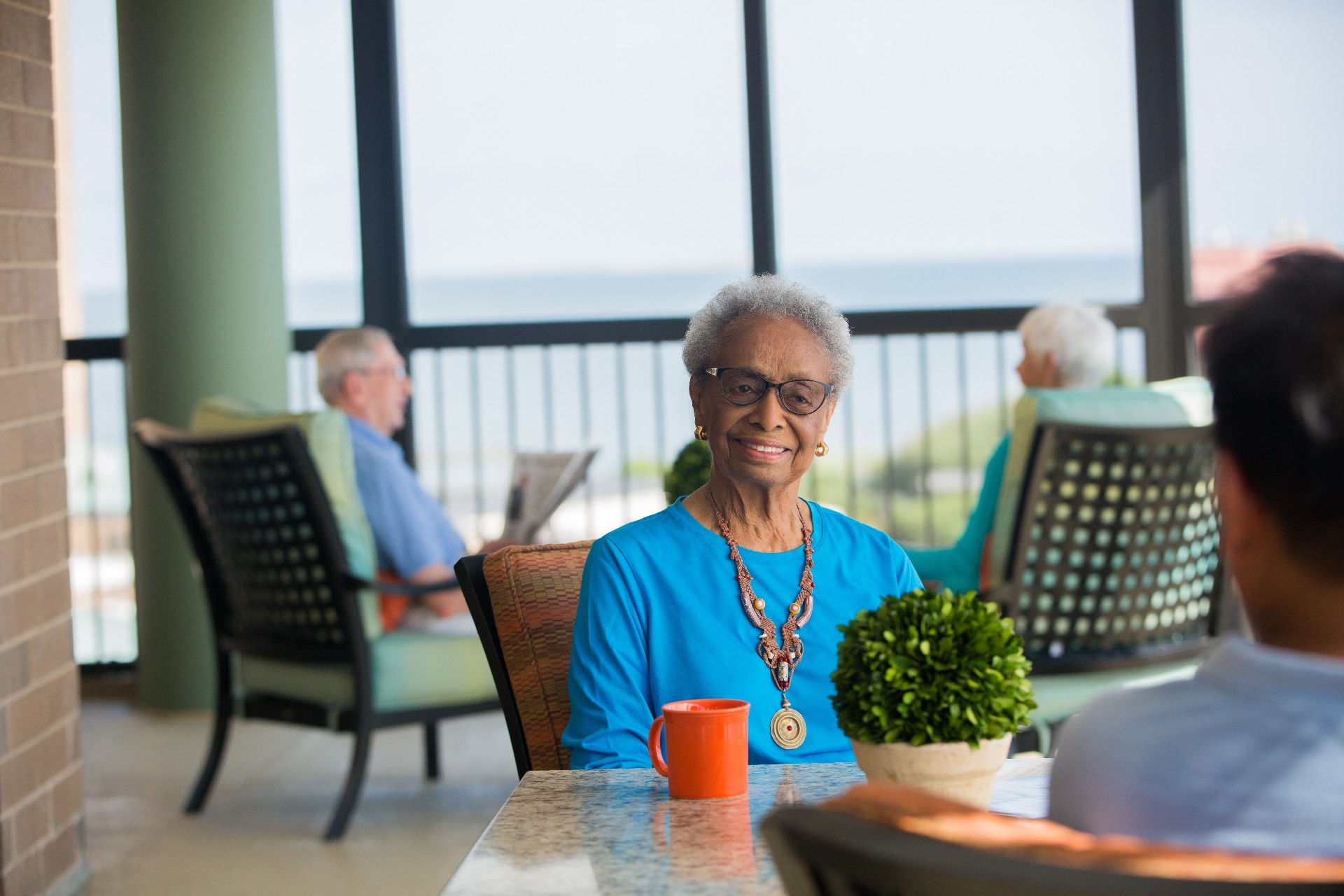 Woman Smiling While Seated at Table Outside