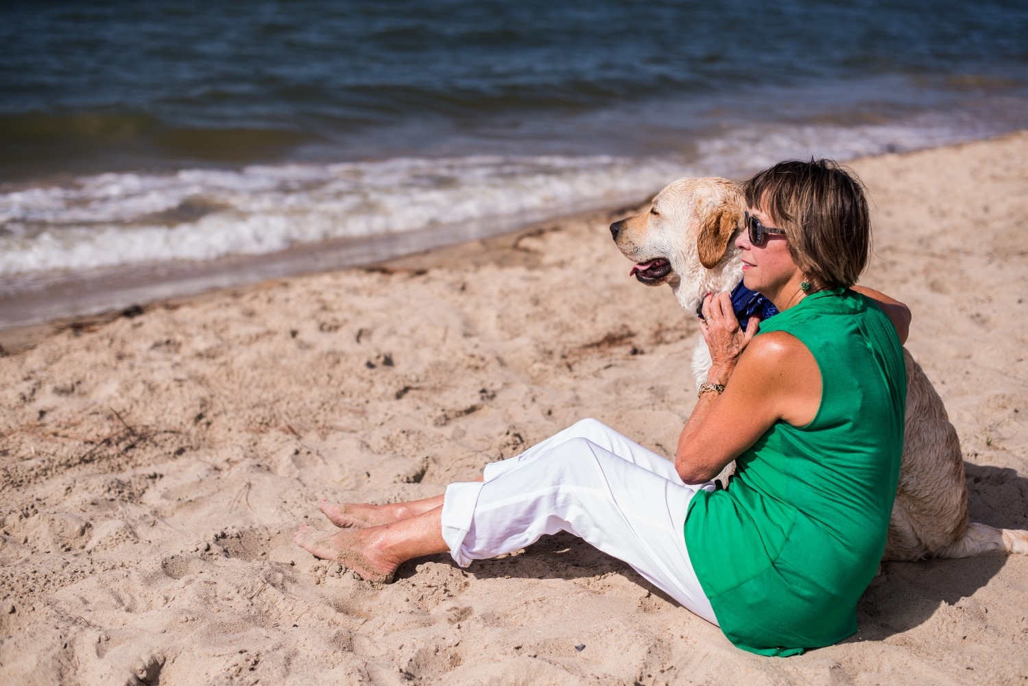 Retired Woman Smiling with Dog at the Beach