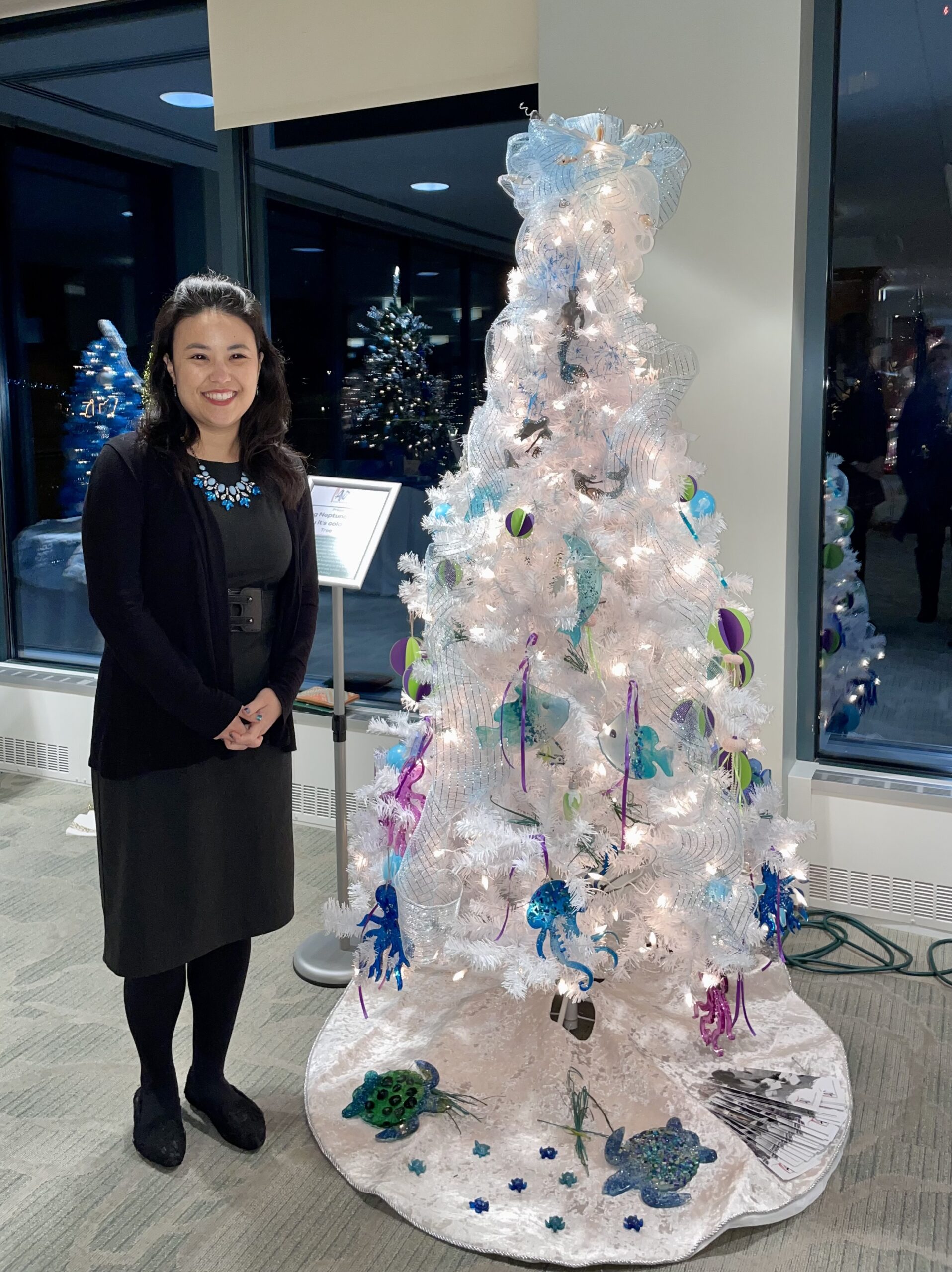 Woman Smiling Next to White Christmas Tree