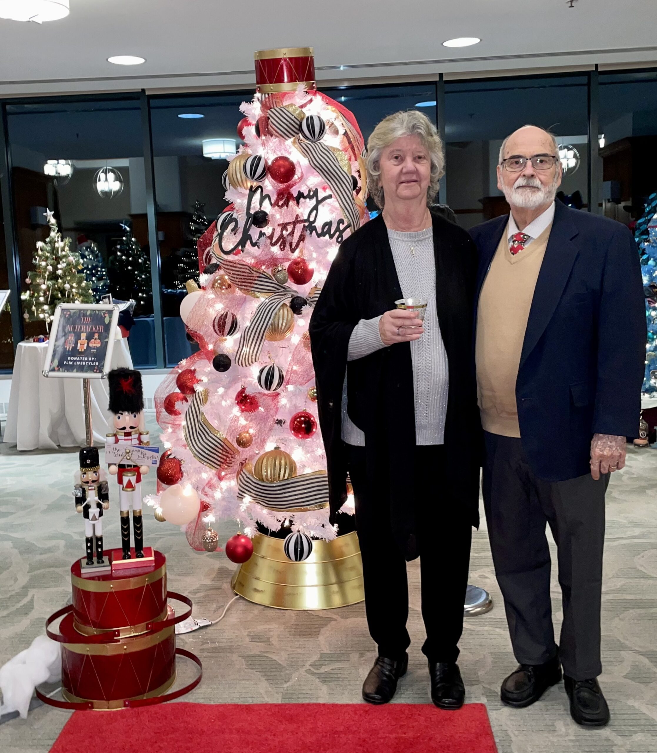 Man and Woman Smiling in Front of Christmas Tree