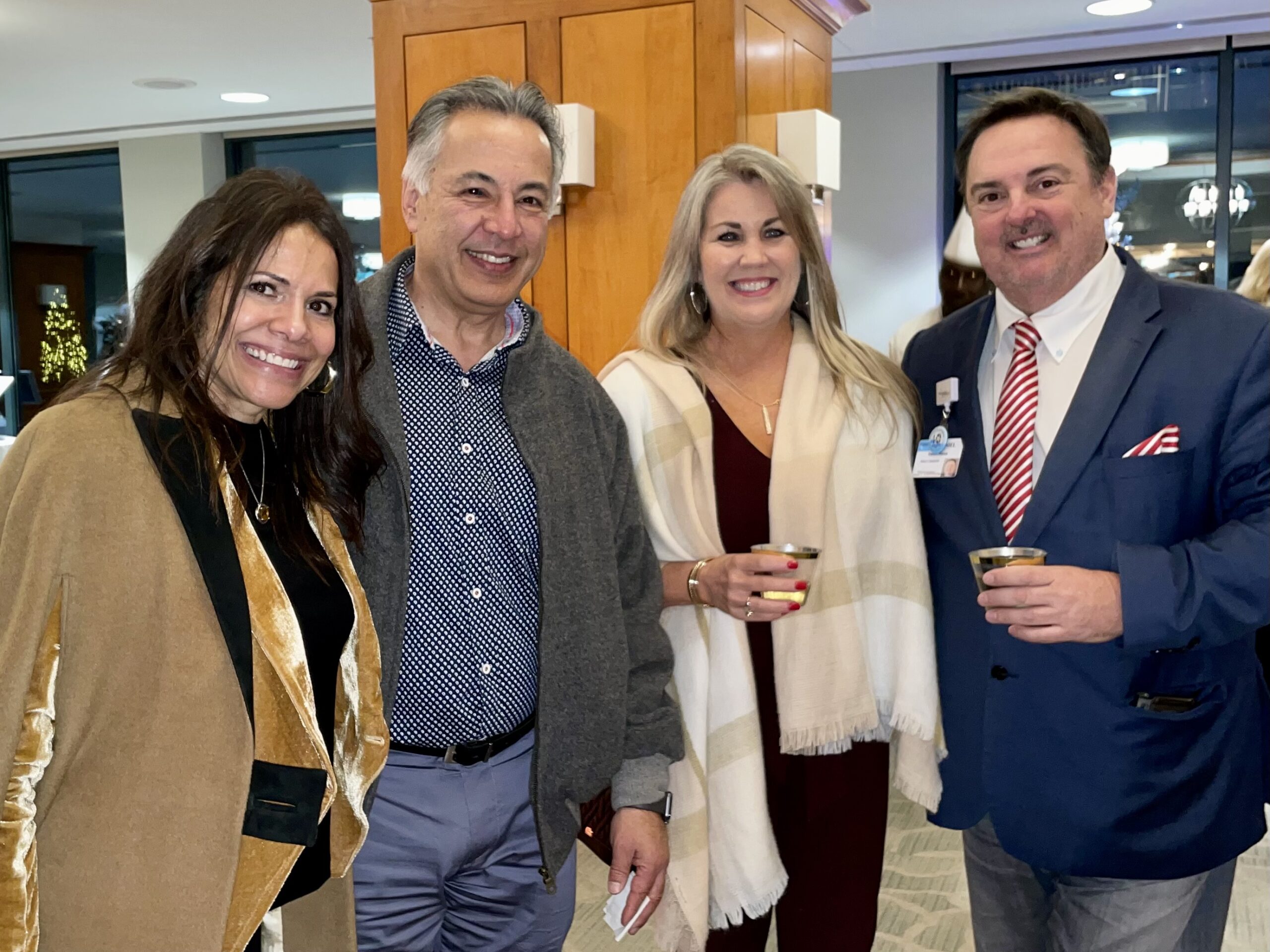 Group of People Smiling and Holding Drinks at Christmas Party