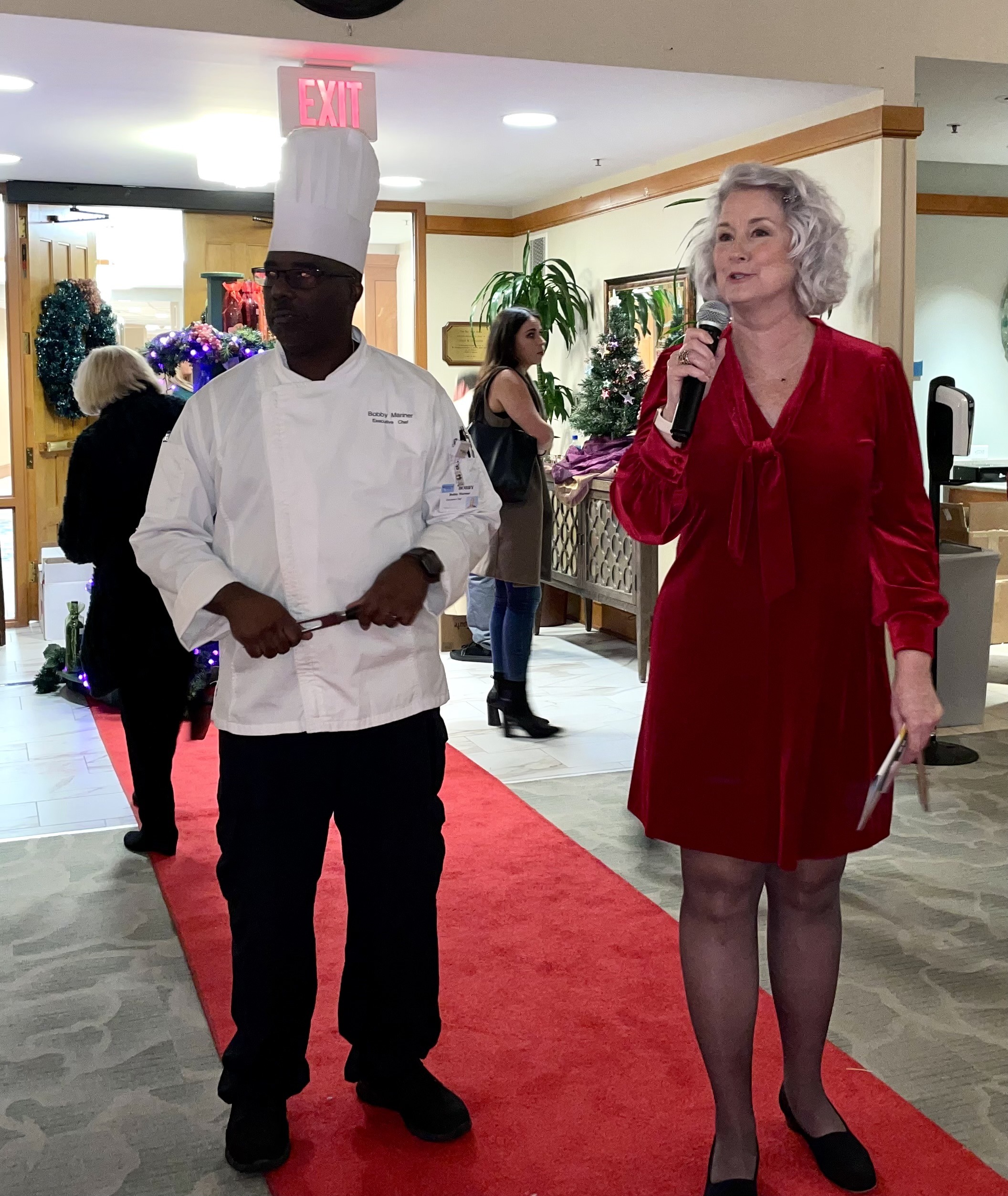 Woman Holding Microphone with Chef Next to Her
