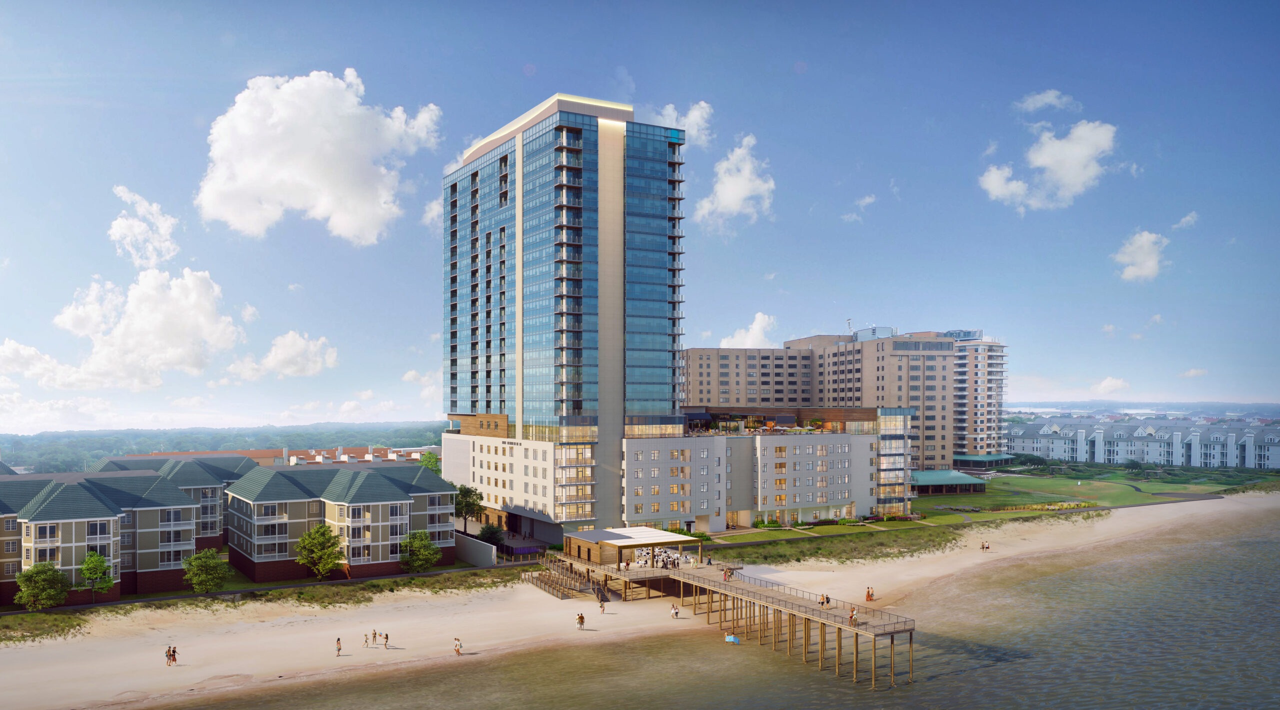 A tall, modern beachfront building with glass exterior and balconies stands by a sandy beach. Smaller structures are nearby, and people can be seen walking along the shore. A picturesque skyline is visible under a blue sky with scattered clouds.