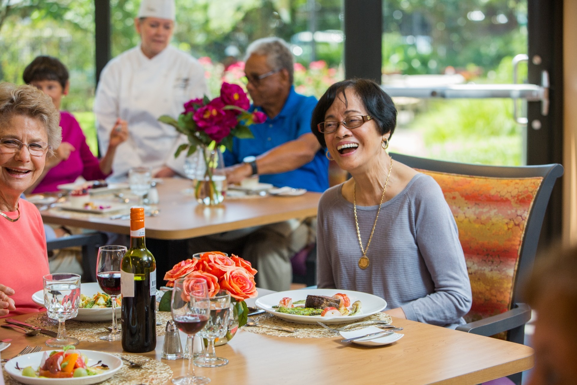 Woman Laughing While Enjoying Dinner