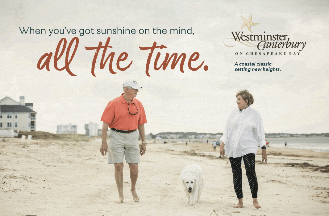 An elderly couple walks along a beach with a white dog. The man wears a red shirt and cap, and the woman wears a white top. Text reads, When youve got sunshine on the mind, all the time, and Westminster Canterbury on Chesapeake Bay.
