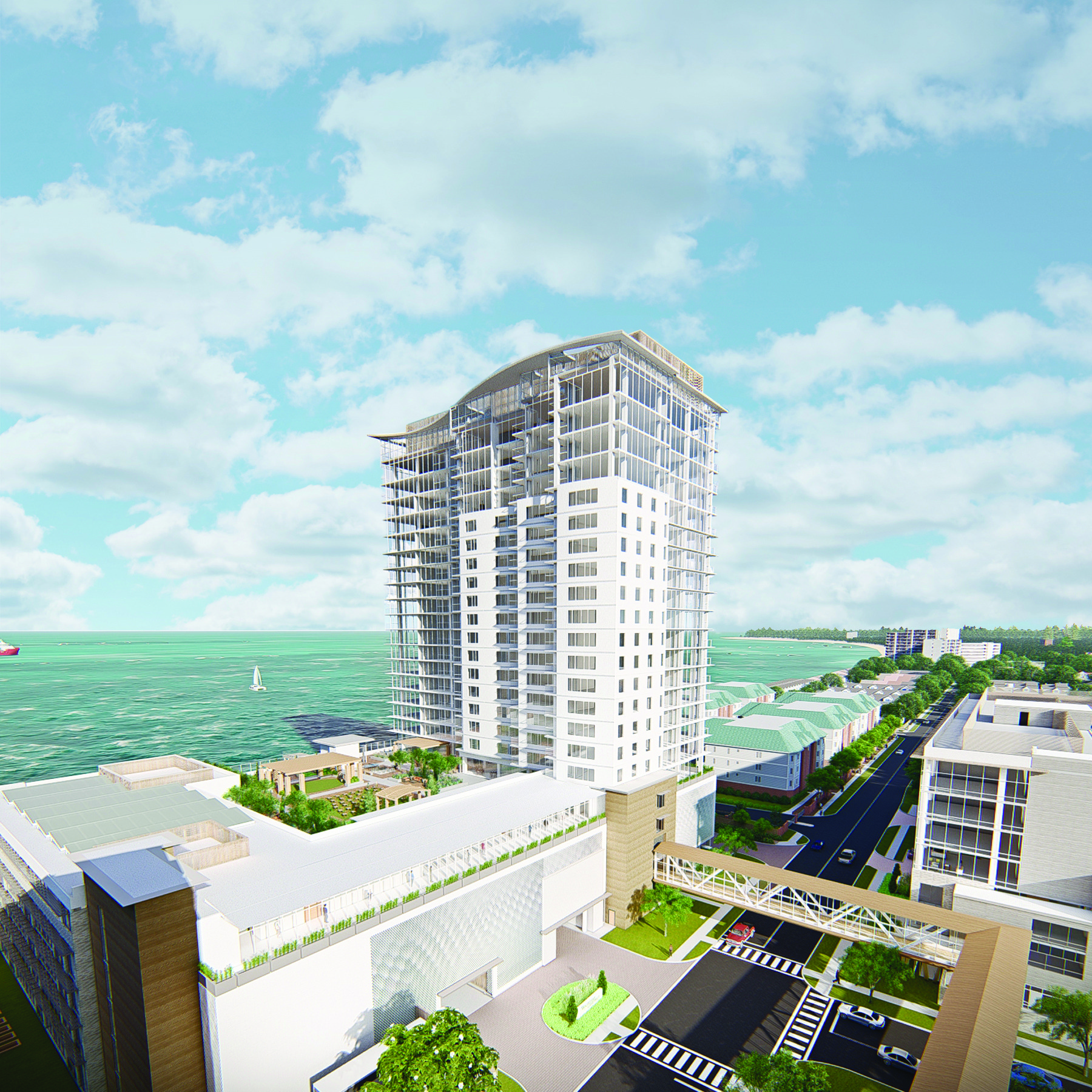 A modern high-rise building overlooks a waterfront, surrounded by greenery and a few other structures. A pedestrian bridge connects nearby areas. The sky is partly cloudy, and a distant sailboat can be seen on the water.