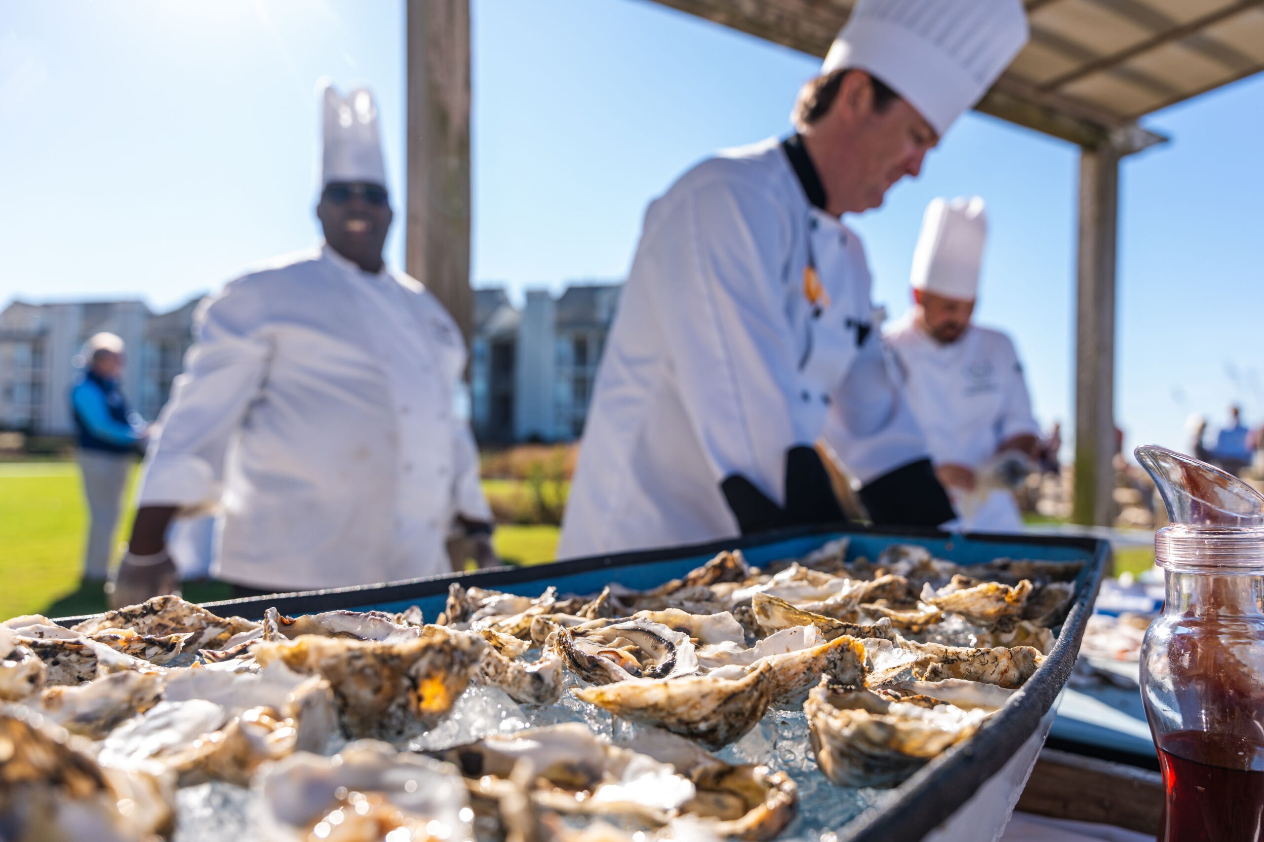 Catering chefs in the background working on shucking oysters